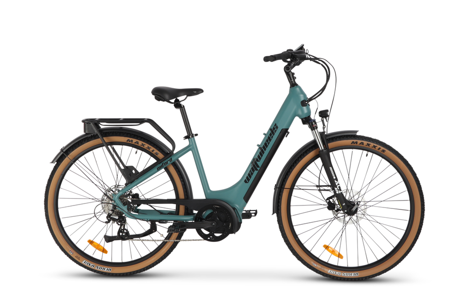 A green Wattwheels electric mountain bike with a low step frame, mid-drive motor, and equipped with lights and a rear rack.